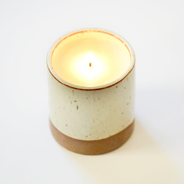 candle in a ceramic cup