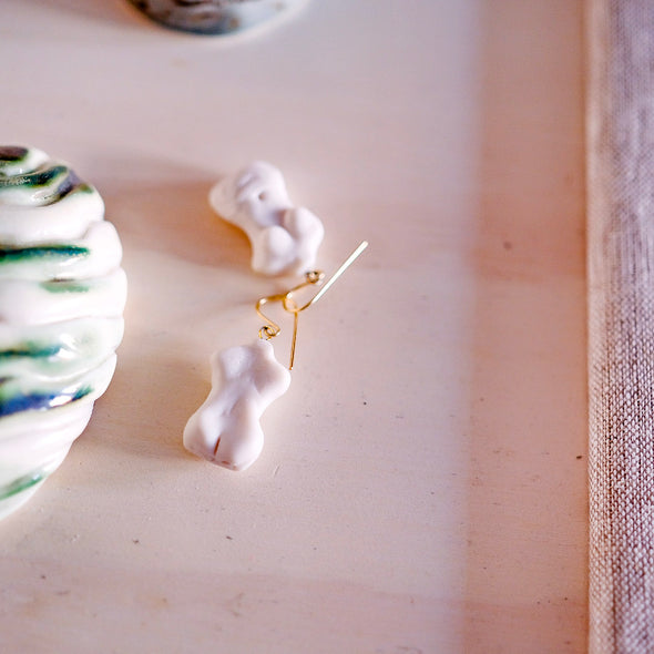 carved porcelain silhouette earrings displayed on a table.